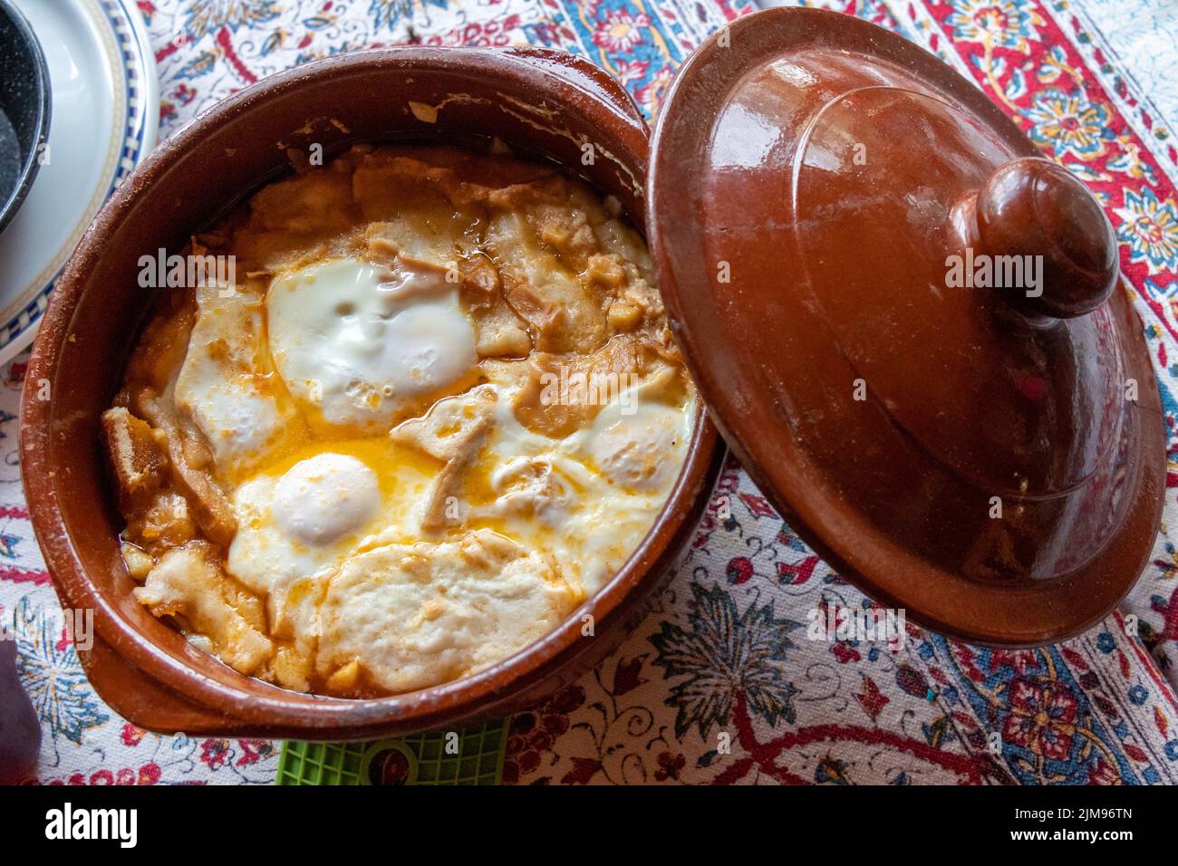 Sopa castellana o sopa de ajo cocida sobre la chimenea y servida en la misma cazuela de barro. Con huevos dentro cocinados con el calor de la sopa. Stock Photo