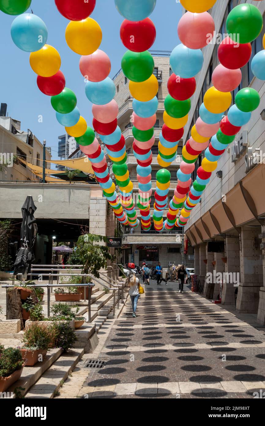 Colorful balloons are suspended above a pedestrian alley in West Jerusalem Israel Stock Photo