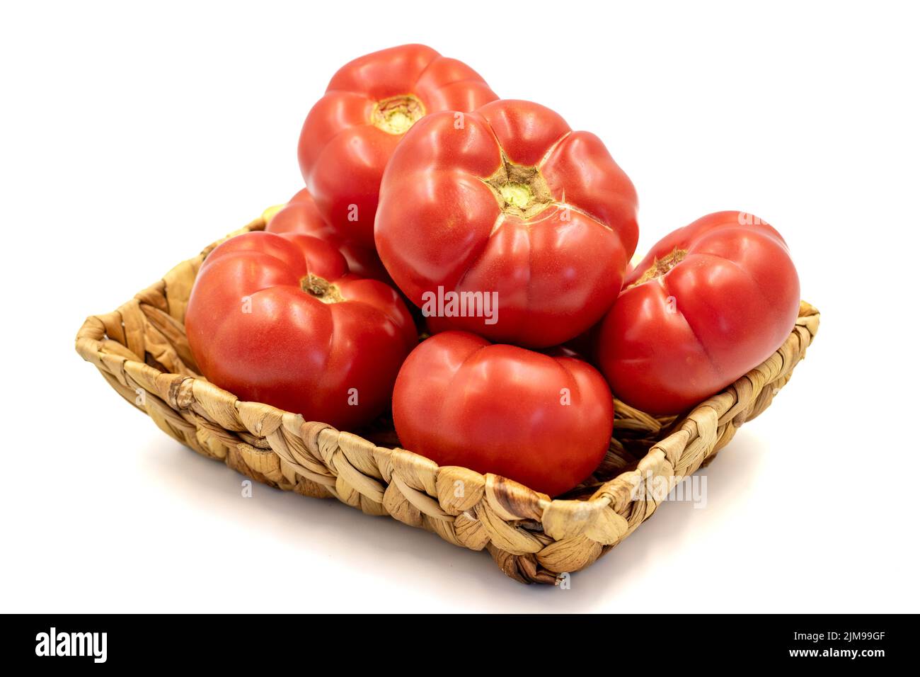 Ripe Tomatoes. Fresh and raw red tomatoes in basket isolated on white background. Organic food. close up Stock Photo