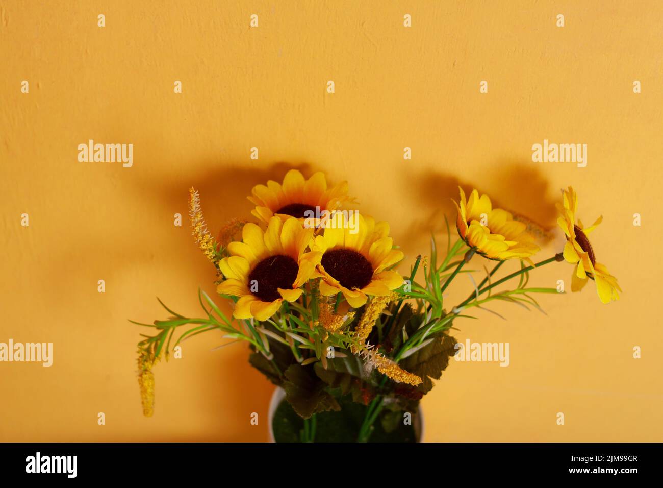 sunflowers in a vase on a isolated yellow background Stock Photo - Alamy
