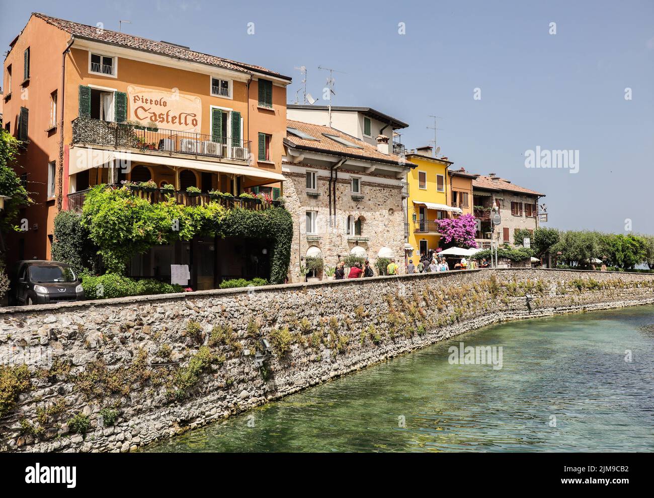 Sirmione, Italy - June 25, 2022: Picturesque Town Sirmione with Colorful Houses in Northern Italy. Beautiful City Architecture with Water Channel. Stock Photo