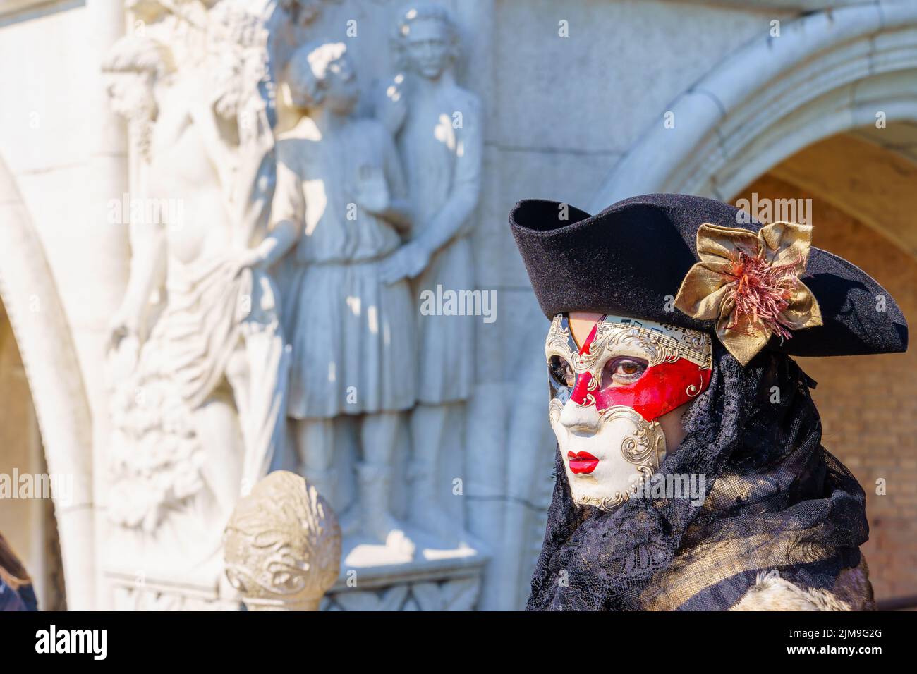 Venice, Italy - March 01, 2022: Woman dressed in traditional costume, in Riva degli Schiavoni waterfront, part of the Venice Mask Carnival, Veneto, It Stock Photo