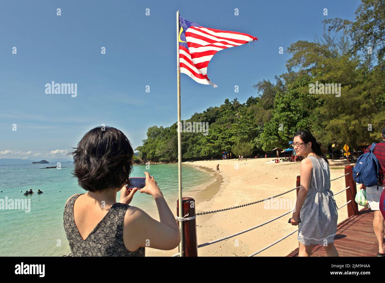 Visitors having a photo session as they are standing on a jetty on Pulau Sapi (Sapi Island), a part of Tunku Abdul Rahman Park in Sabah, Malaysia. Stock Photo