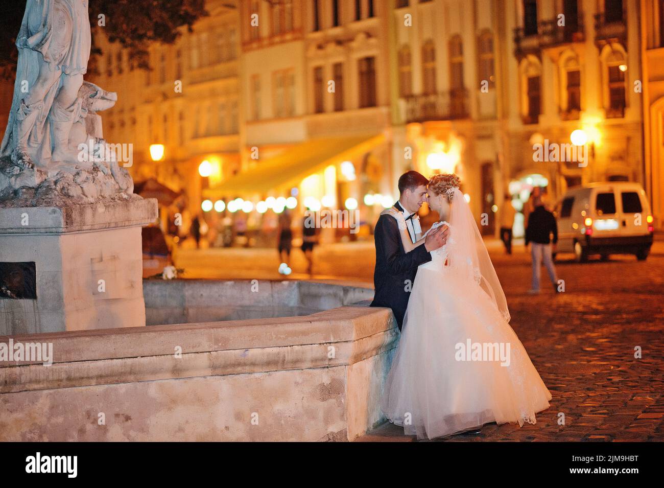 Wedding couple in love on streets of evening Lviv, Ukraine Stock Photo