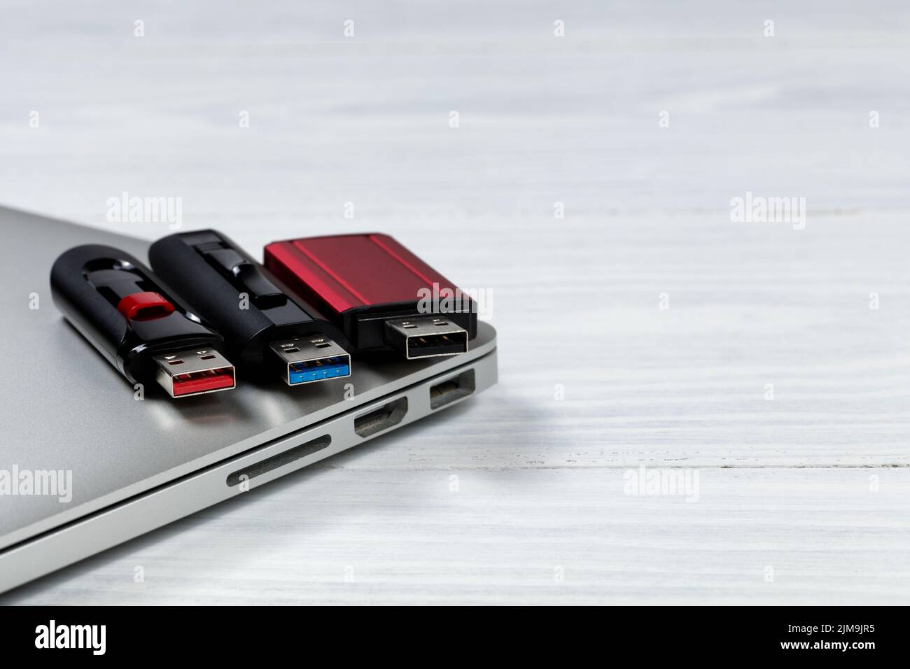 Thumb drives with different colors for USB speed technologies on top of computer Stock Photo