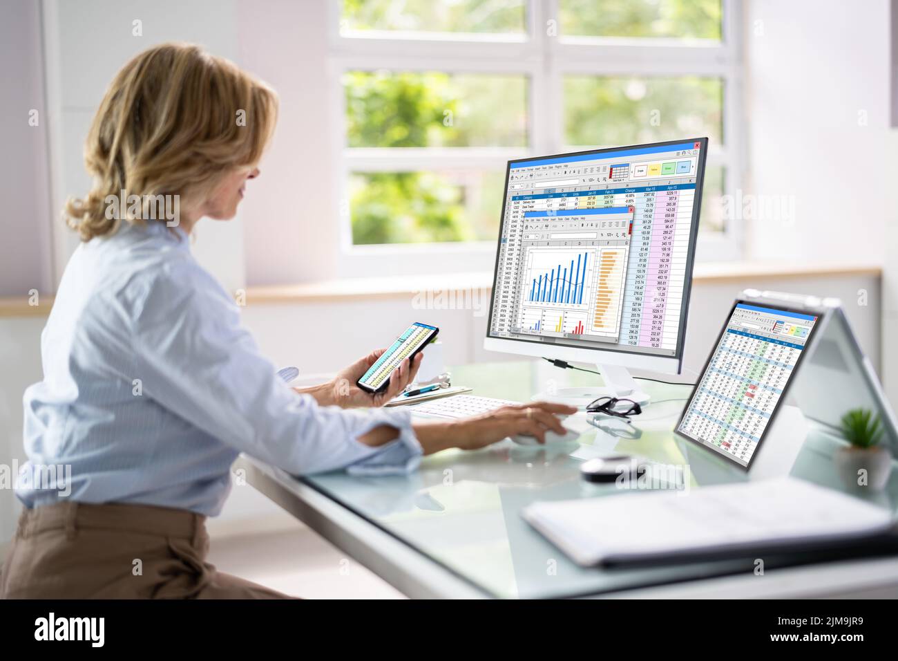 Financial Analyst Using Spreadsheet Software On Desktop Computer Stock Photo