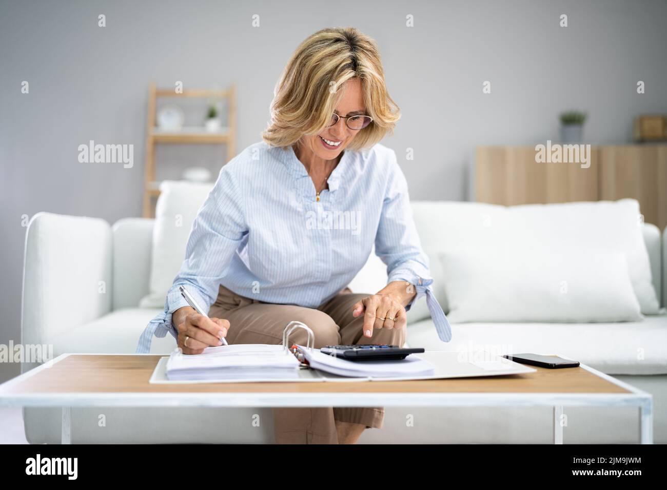 Senior Doing Finances Paperwork For Retirement. Elder Woman Invoice Stock Photo