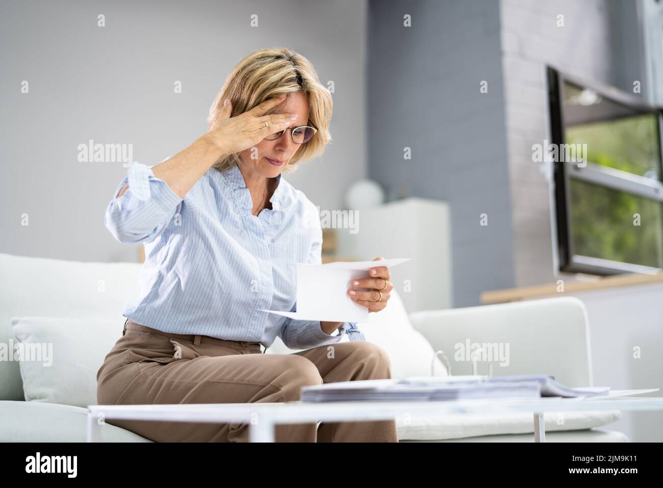 Portrait Of A Sad Woman Reading Letter Stock Photo