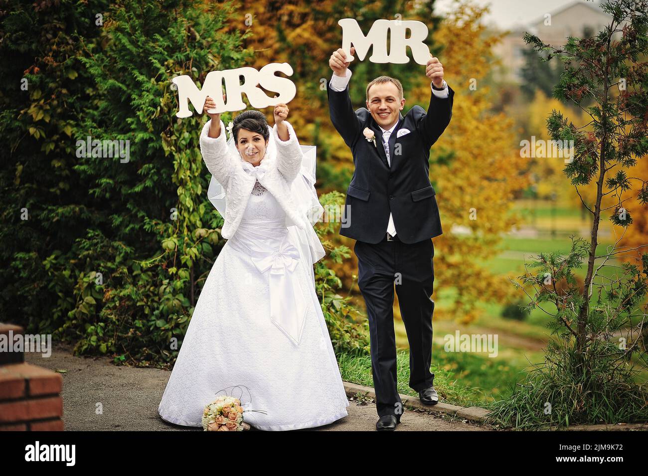 Happy wedding couple in autumn day with sign mrs mr Stock Photo - Alamy