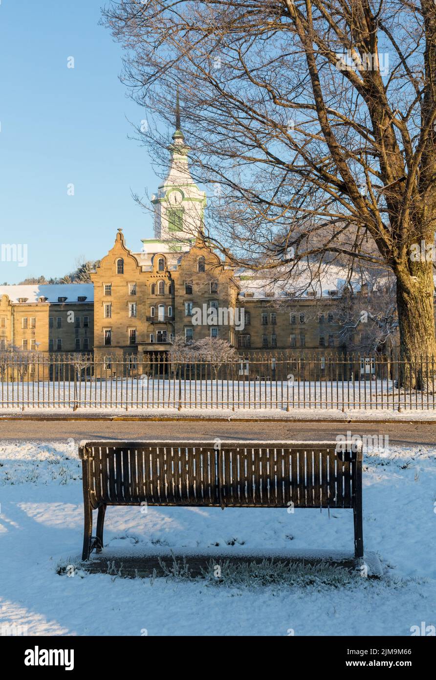 Bench in snow outside Trans-Allegheny Lunatic Asylum Stock Photo