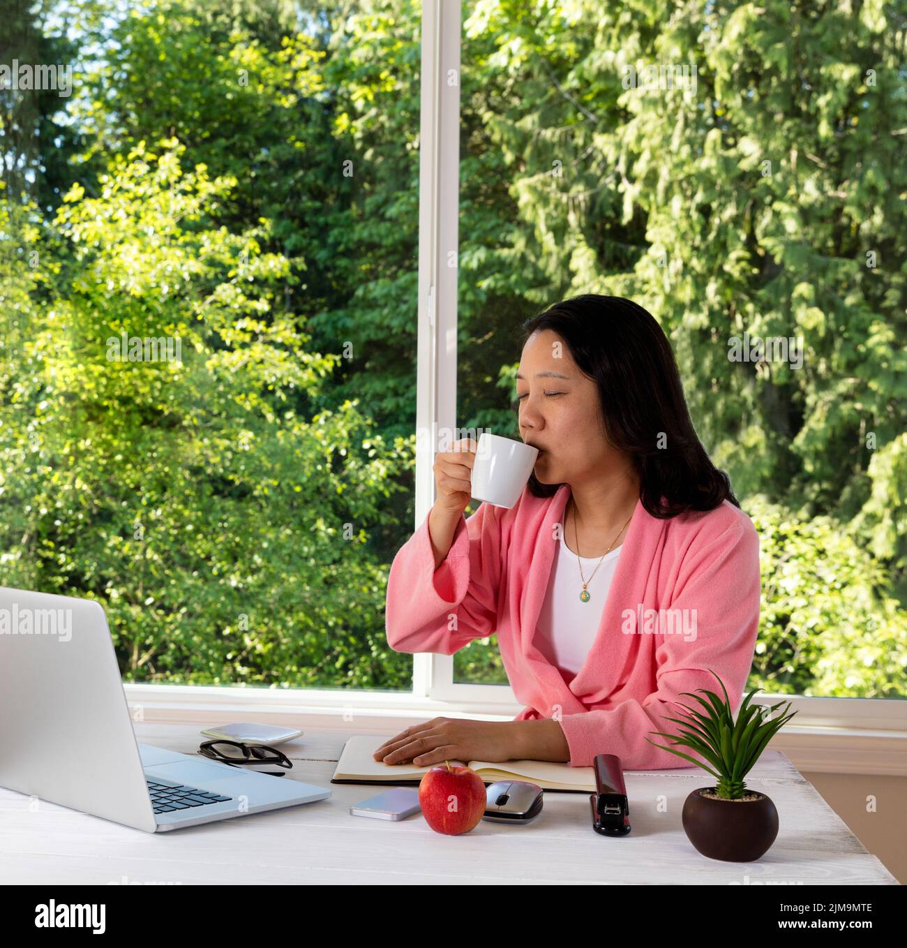 Mature woman enjoying her coffee in the morning while working from home