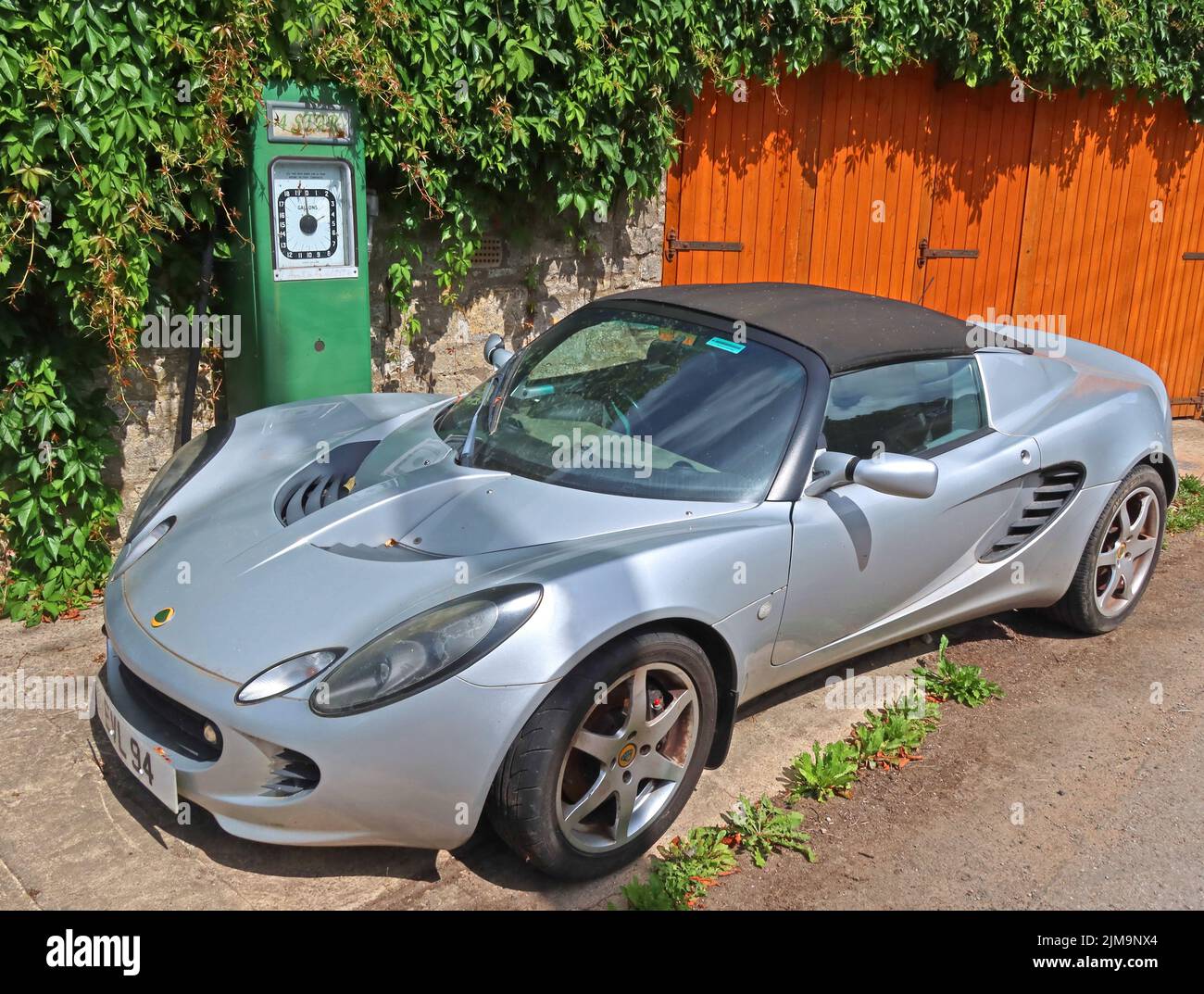 Silver Lotus, 1800 EVL94, with Avery petrol pump, Eastcombe, Gloucestershire, Cotswolds, England, UK, GL6 7EB Stock Photo