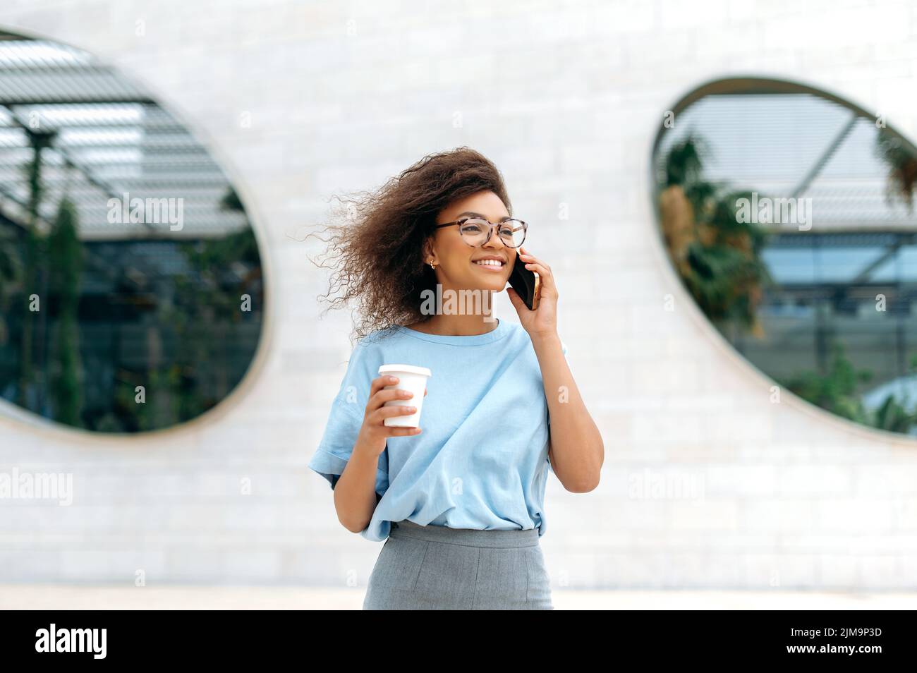 Phone talk, communication. Positive young african american curly woman
