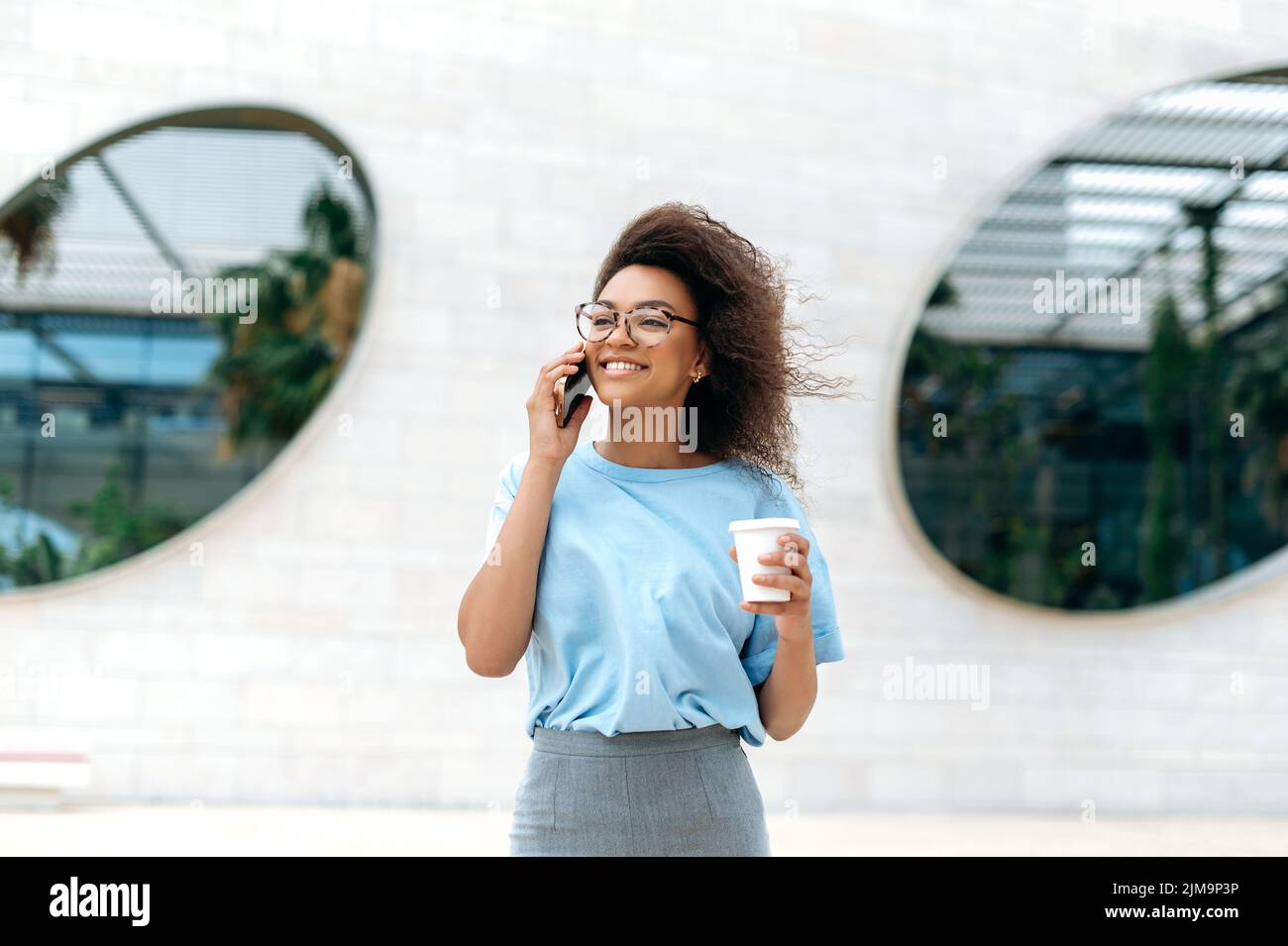 Side View Pleasant Millennial Mixed Race Woman Holding Smartphone