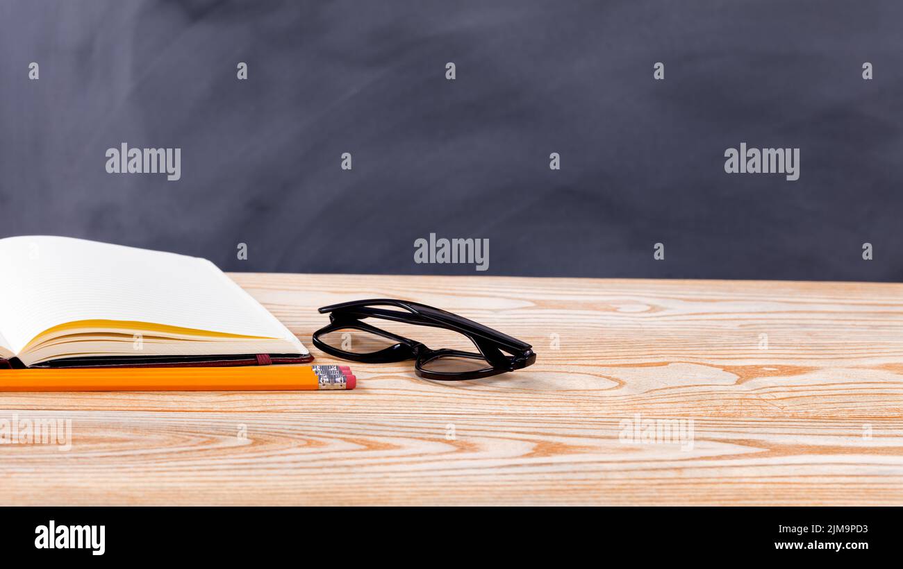 Back to school basic objects in front of erased black chalkboard Stock Photo