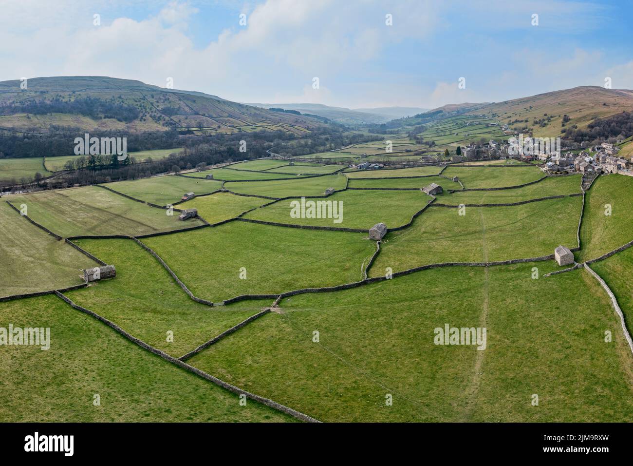 panoramic elevated view of patchwork fields and traditional stone barns at gunnerside in swaledale north yorkshire Stock Photo