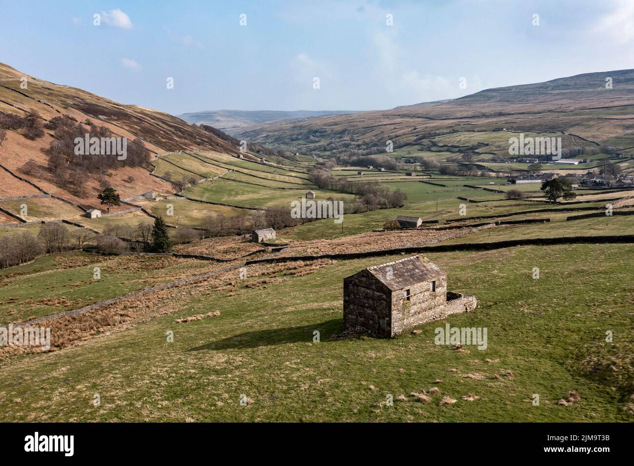 Stone barns in farmland between Angram and Thwaite in Swaledale North Yorkshire Stock Photo