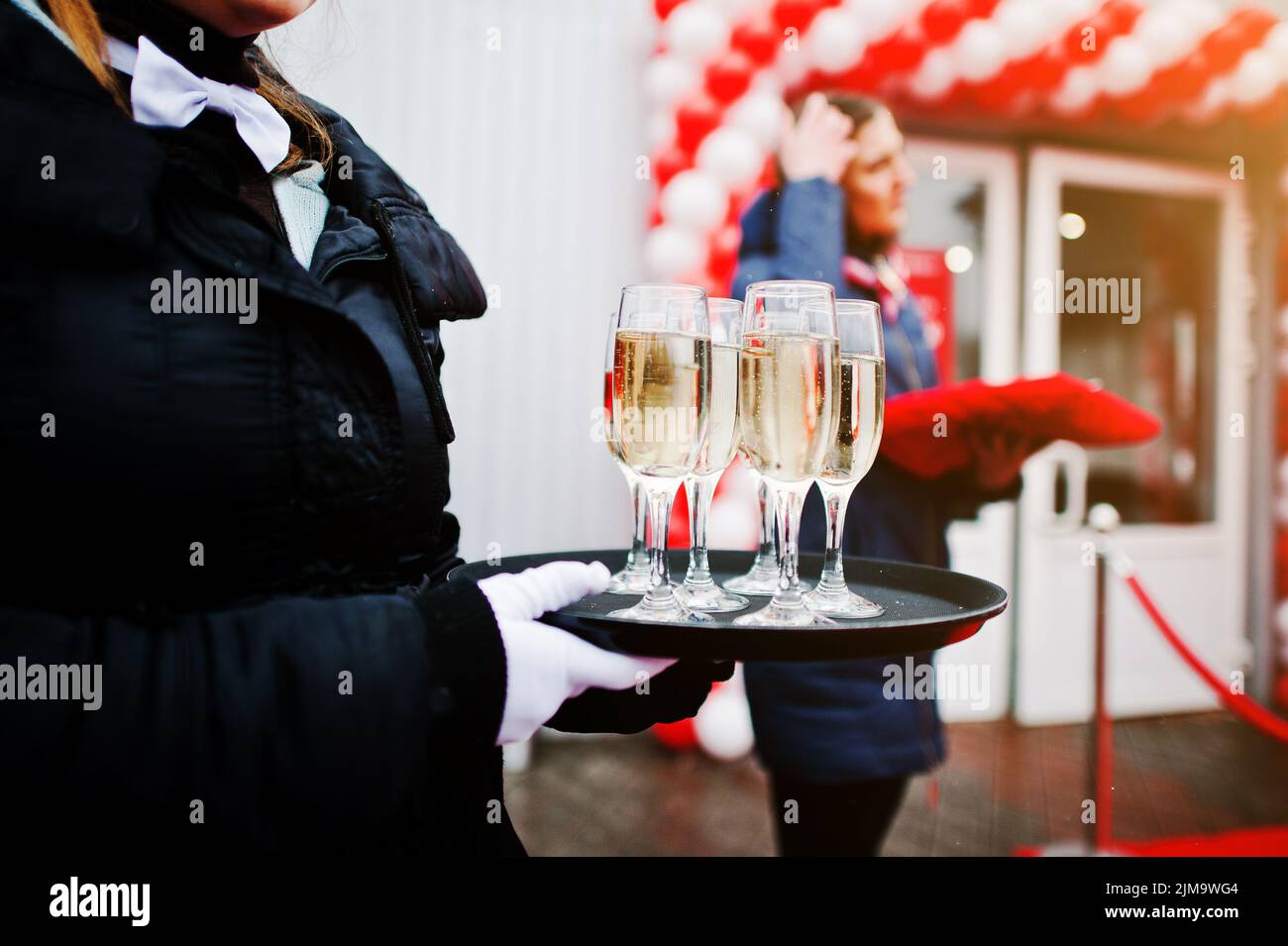 Waiter with a tray of champagne glasses at the official opening Stock Photo