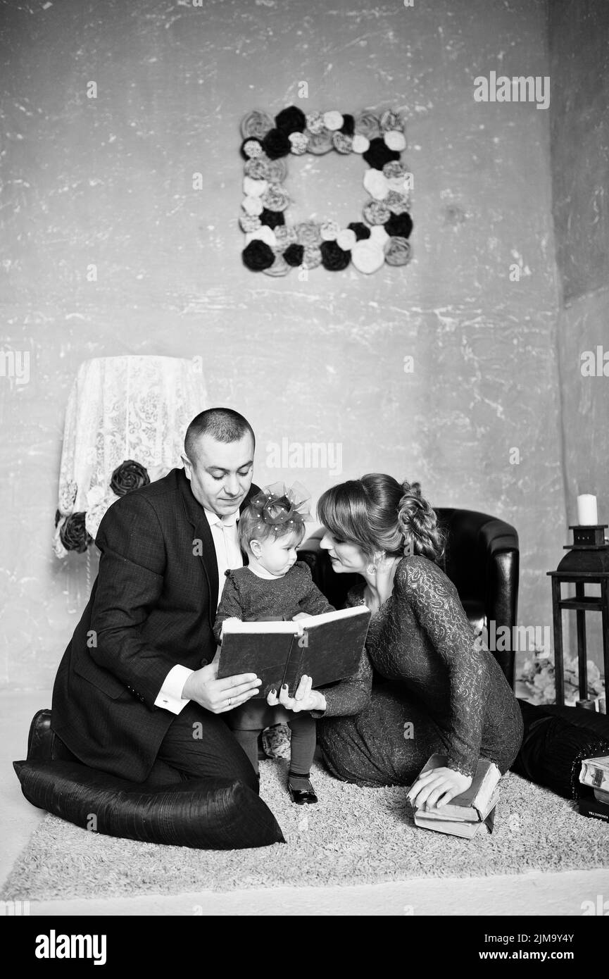 Happy family with daughter read the old book on rugs background vintage room with decor Stock Photo