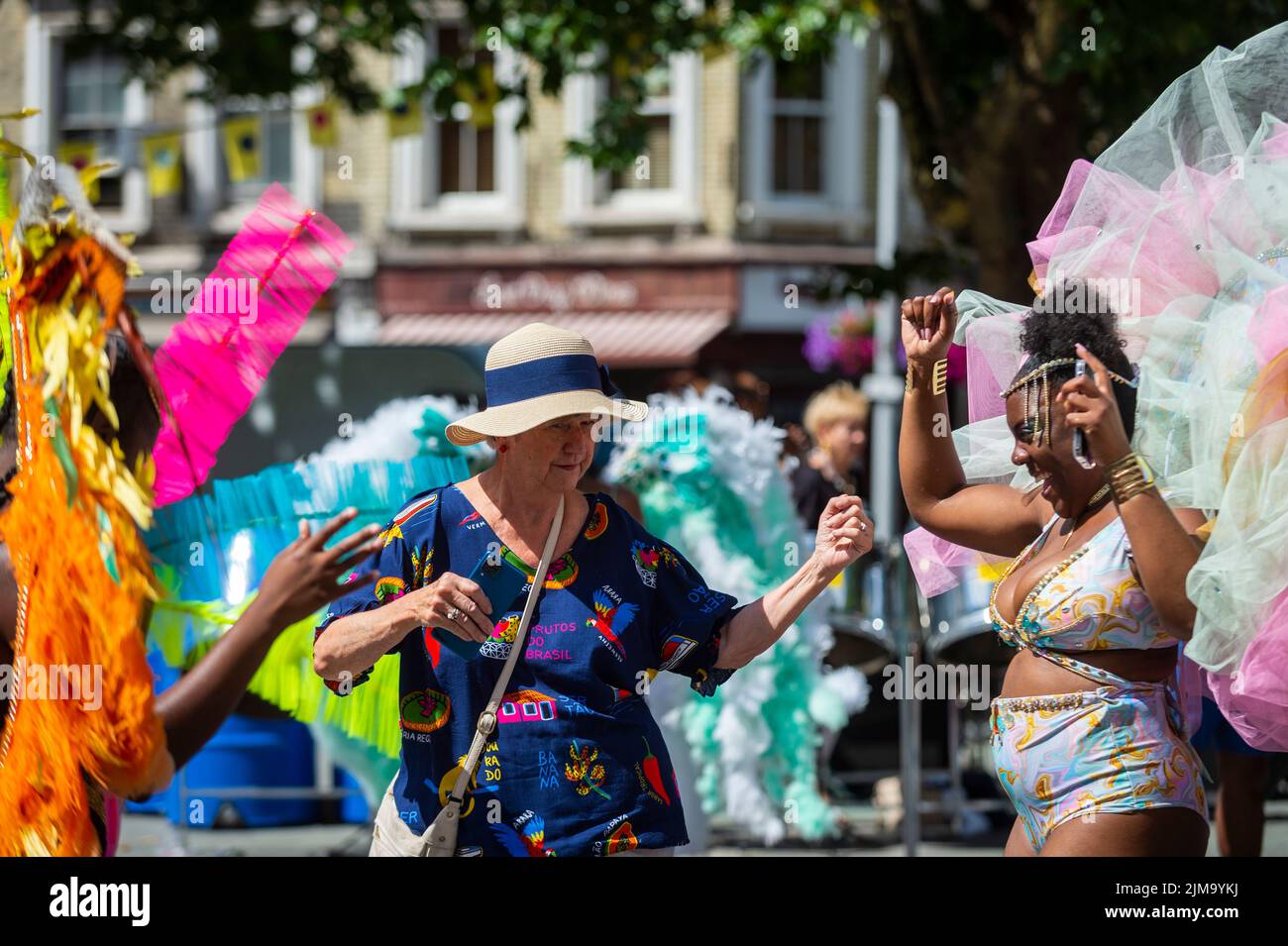 London, UK.  5 August 2022. A member of the public joins in with members of Funatiks costumes performing at Carnival in Chelsea, a community event showcasing carnival costumes, music and culture ahead of Notting Hill Carnival.  The show is part of this year’s Kensington & Chelsea Festival.  Credit: Stephen Chung / Alamy Live News Stock Photo