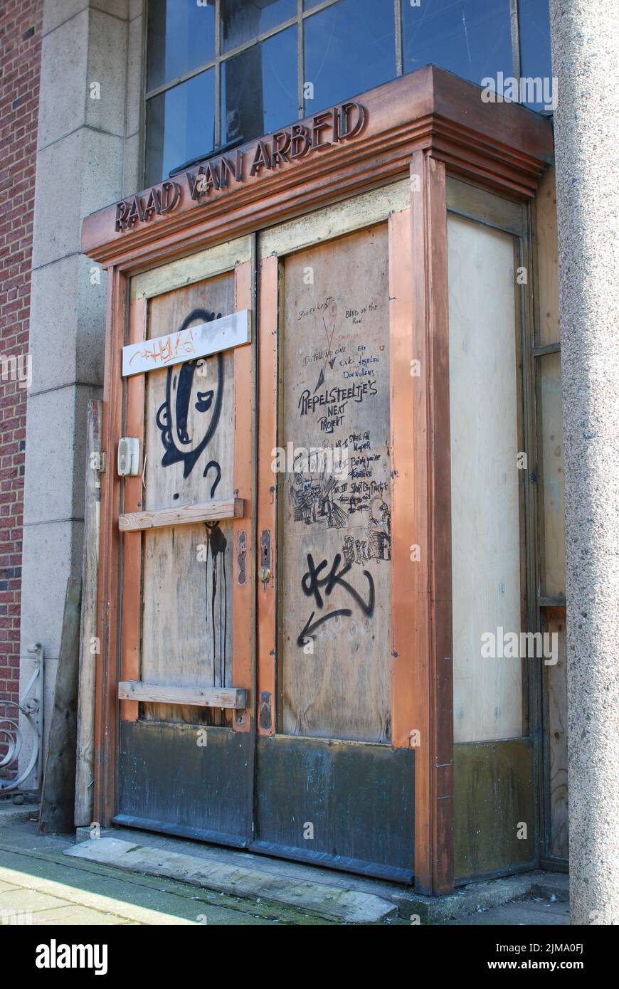 A vertical shot of the abandoned and dilapidated entrance of the Labour Council 'Raad van Arbeid' Stock Photo