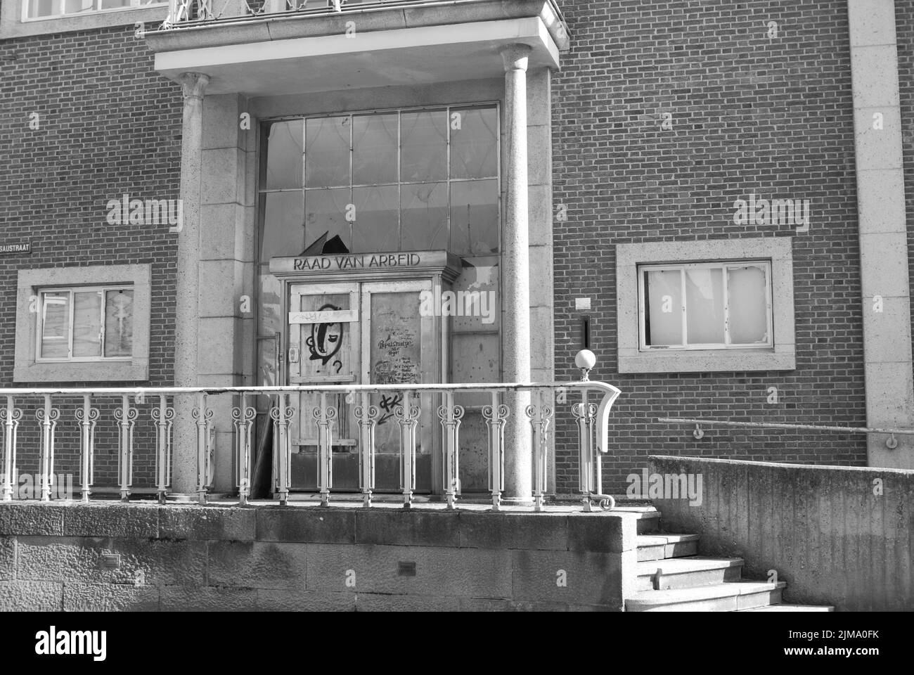 A grayscale shot of the abandoned and dilapidated entrance of the Labour Council 'Raad von Arbeid' Stock Photo