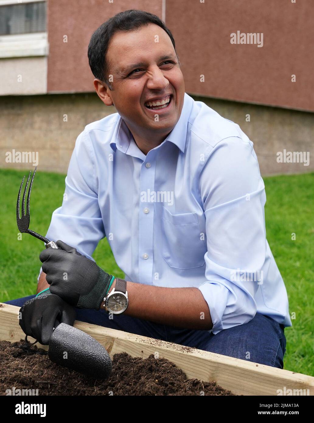 Scottish Labour leader Anas Sarwar plants seeds in a community garden during his to visit Acre Community Hall, Glasgow, where he met volunteers in the food bank and later planted seeds in a vegetable patch. Picture date: Friday August 5, 2022. Stock Photo