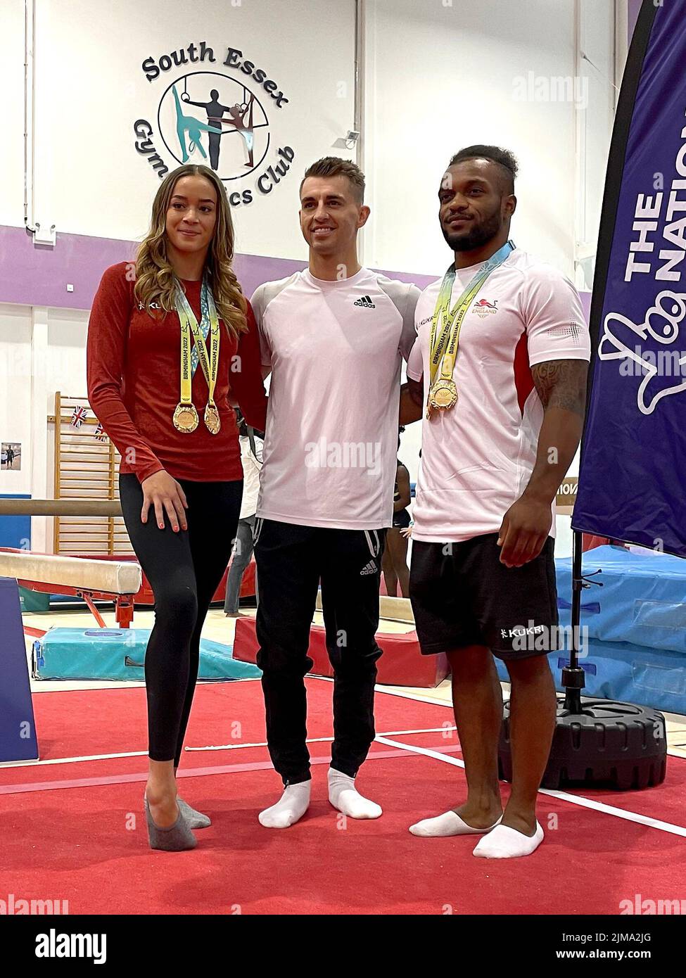 Max Whitlock (centre), Georgia-Mae Fenton (left) and Courtney Tulloch at the South Essex Gymnastics Club, Essex. Picture date: Friday August 5, 2022. Max Whitlock, Courtney Tulloch and Georgia-Mae Fenton surprised a room full of young children who have been supporting Team England throughout the Games. Stock Photo