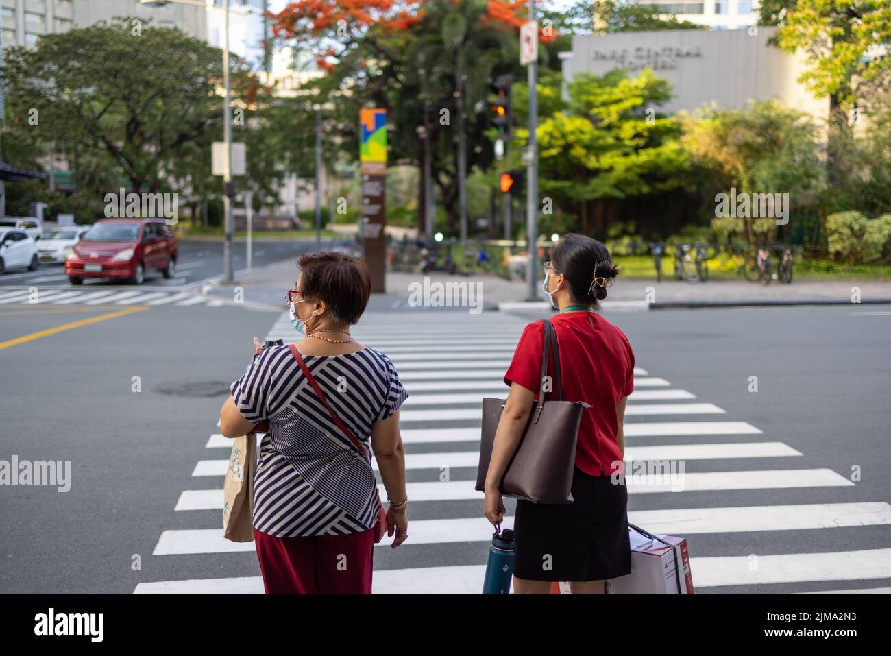 Two pedestrians waiting to cross the road outside the Glorietta Mall Stock Photo