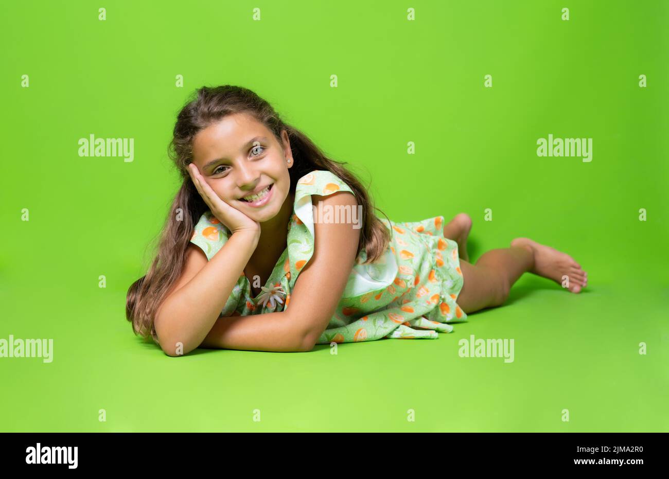 Portrait of a happy smiling cute little girl lying on the floor ...