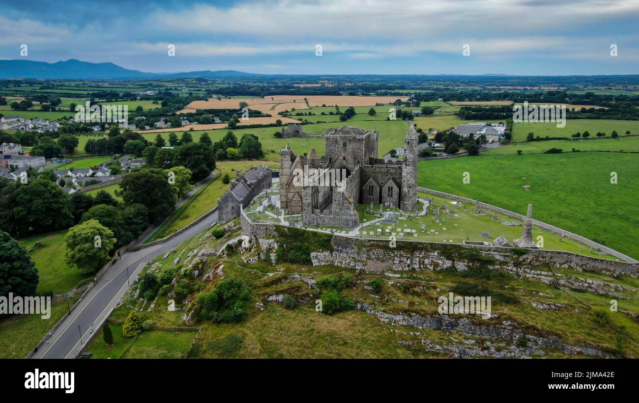 The Rock of Cashel against green fields and a cloudy sky, County ...