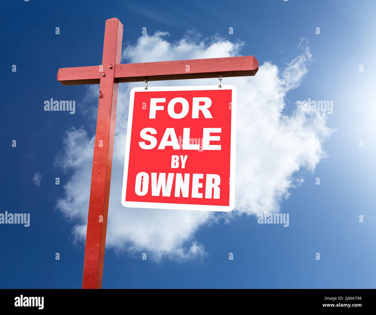 For Sale sign for home in front of blue sky Stock Photo