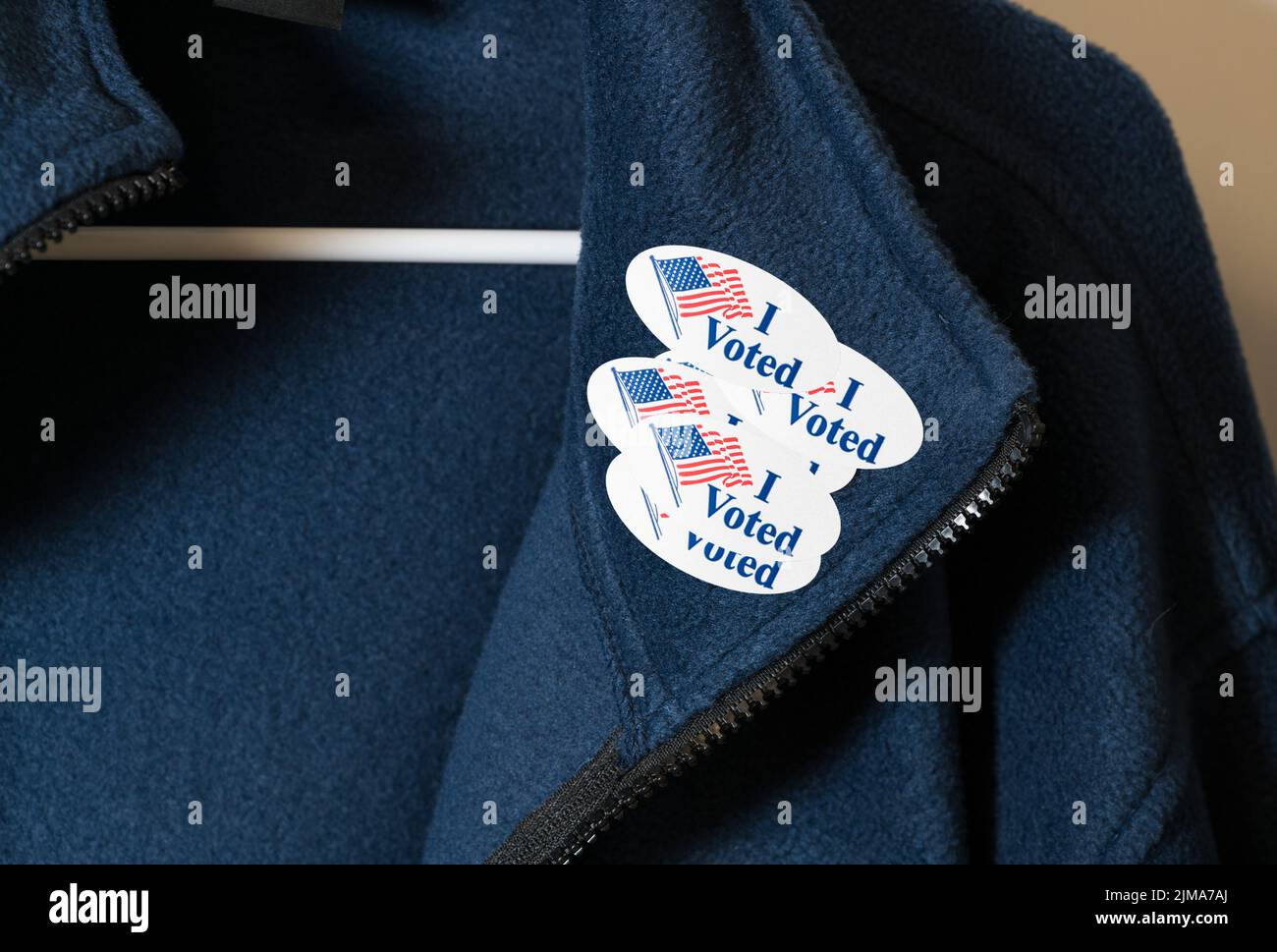 Many I Voted stickers on blue jacket hung on hanger Stock Photo
