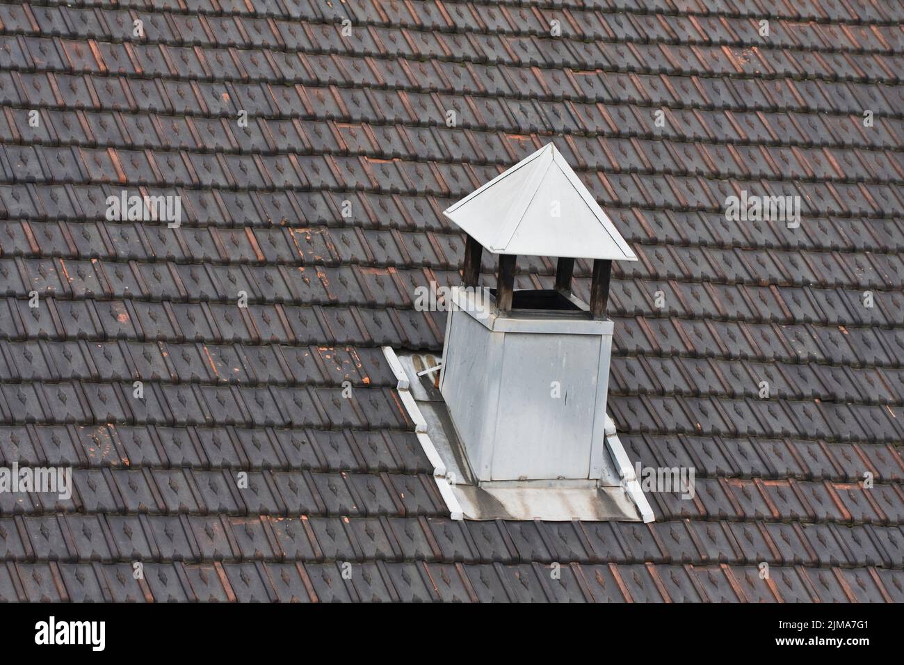 Metal chimney on black tiled roof Stock Photo Alamy