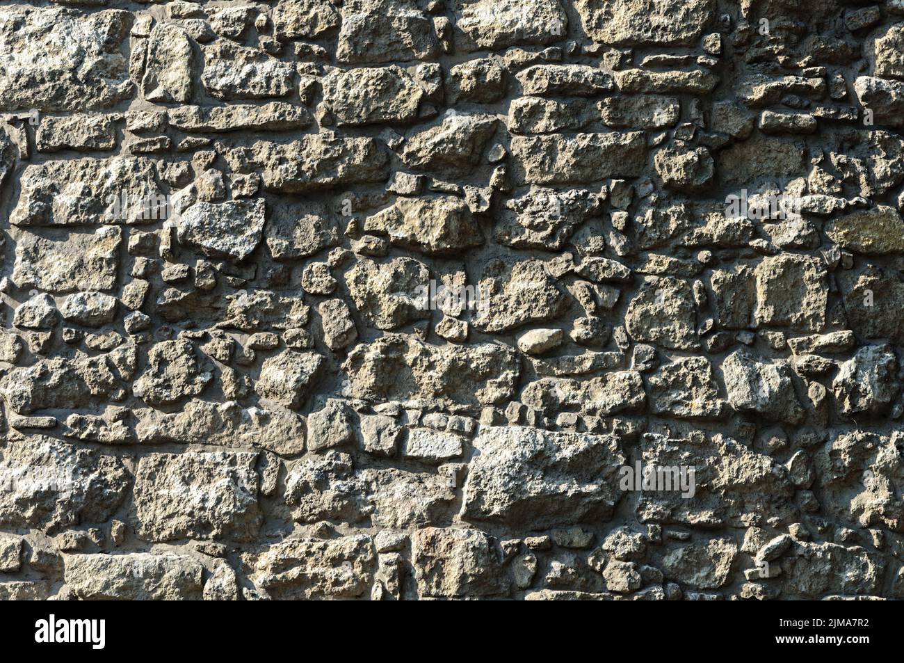 Gray rough stone wall background Stock Photo - Alamy