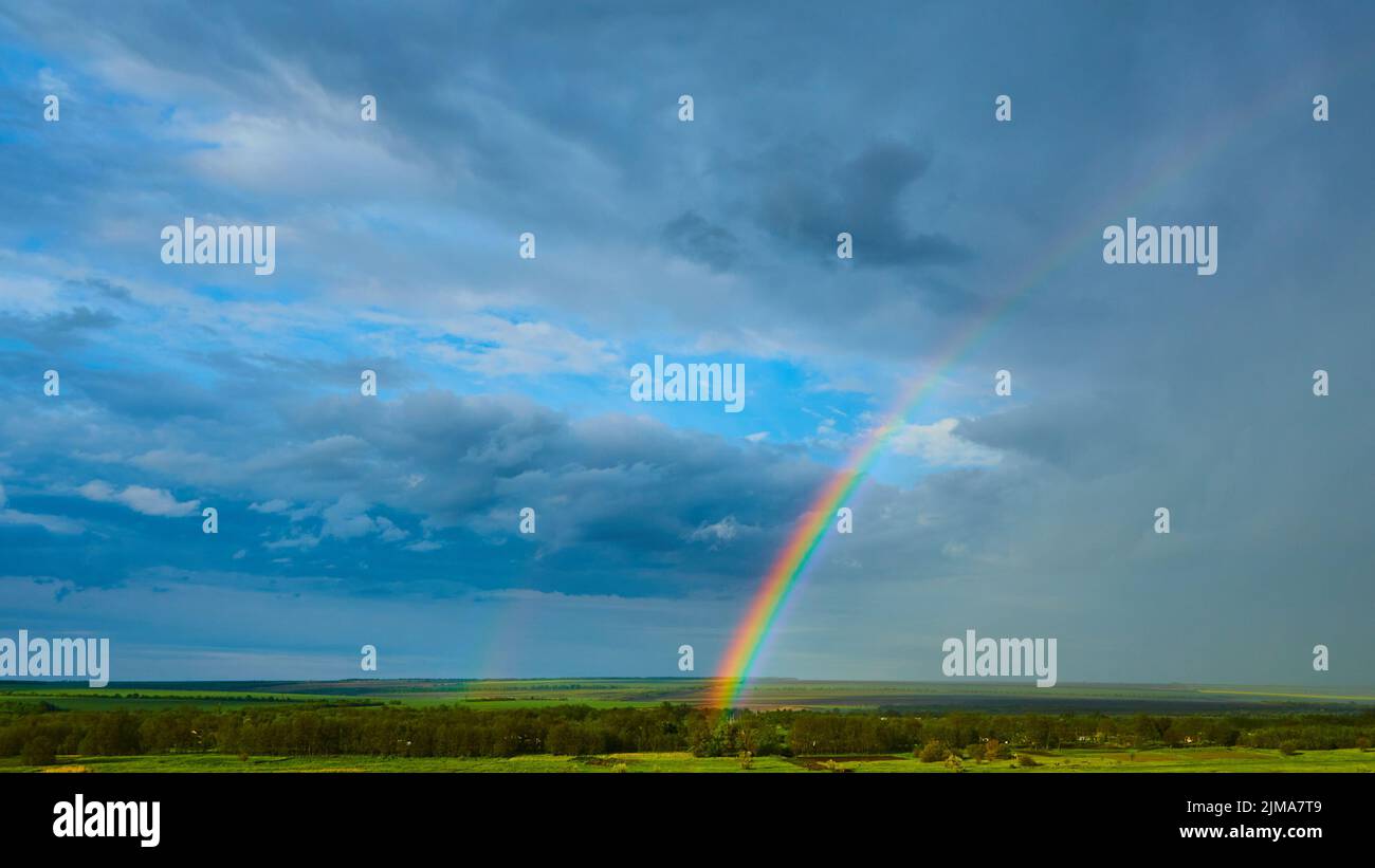 The Rainbow over Rural Landscape after Thunderstorm. Stock Photo