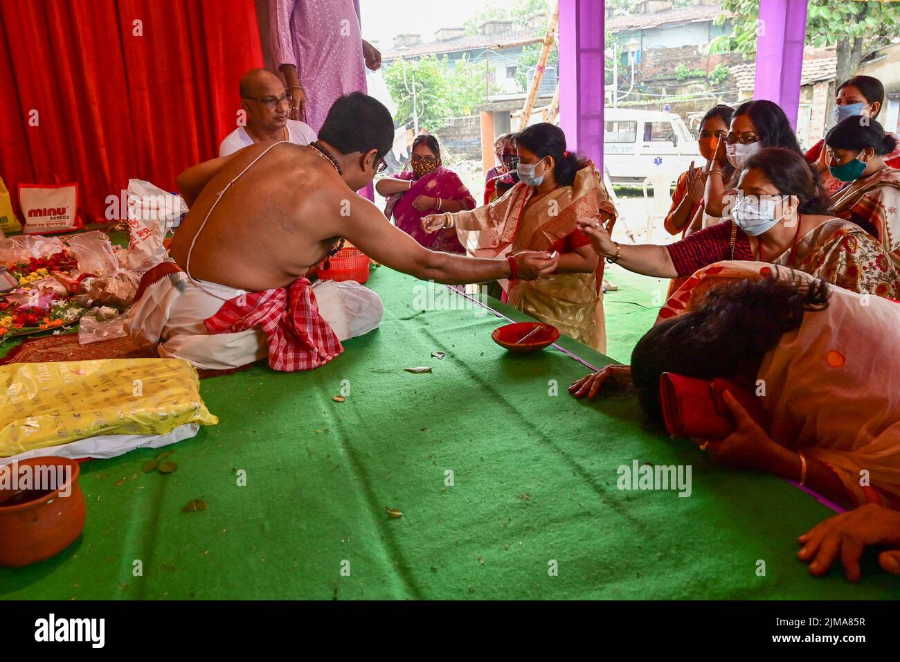 Howrah, West Bengal, India - 14th October 2021 : Hindu Purohit blessing devotees during pushpanjali puja to Goddess Durga, sacred ritual to worship th Stock Photo