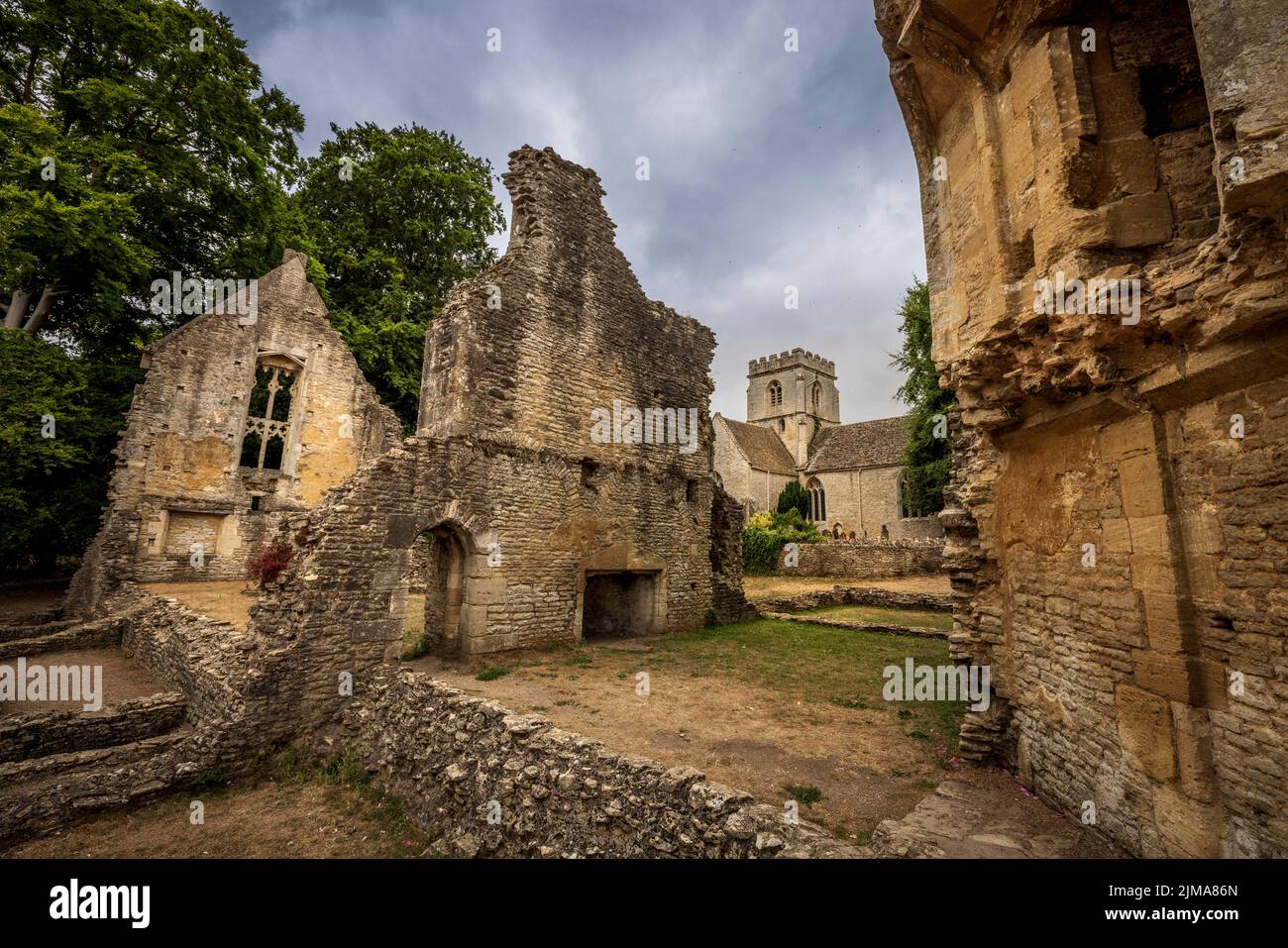 The atmospheric ruins of Minster Lovell Hall with St Kenelm’s Church in the background, Cotswolds, Oxfordshire, England Stock Photo