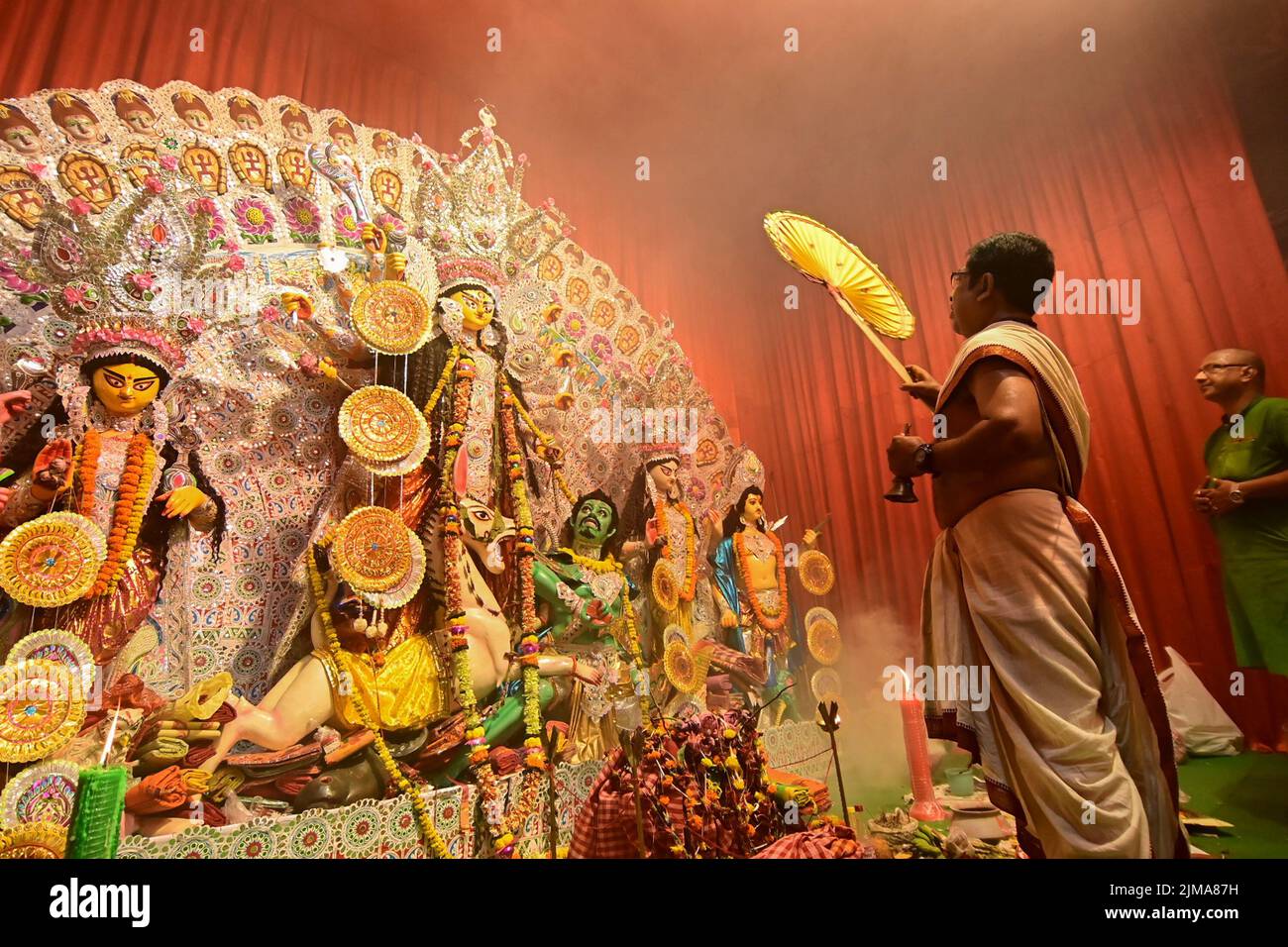 Howrah, India -October 13, 2021 : Hindu Priests worshipping Goddess Durga with ghanta, chamor and hand fan. Ashtami puja aarati - sacred  worshipping. Stock Photo