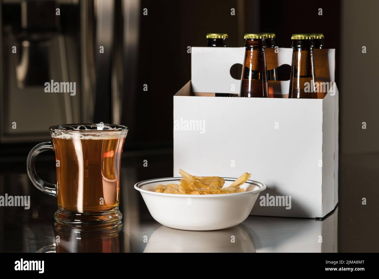 Six pack of brown beer bottles on kitchen counter Stock Photo