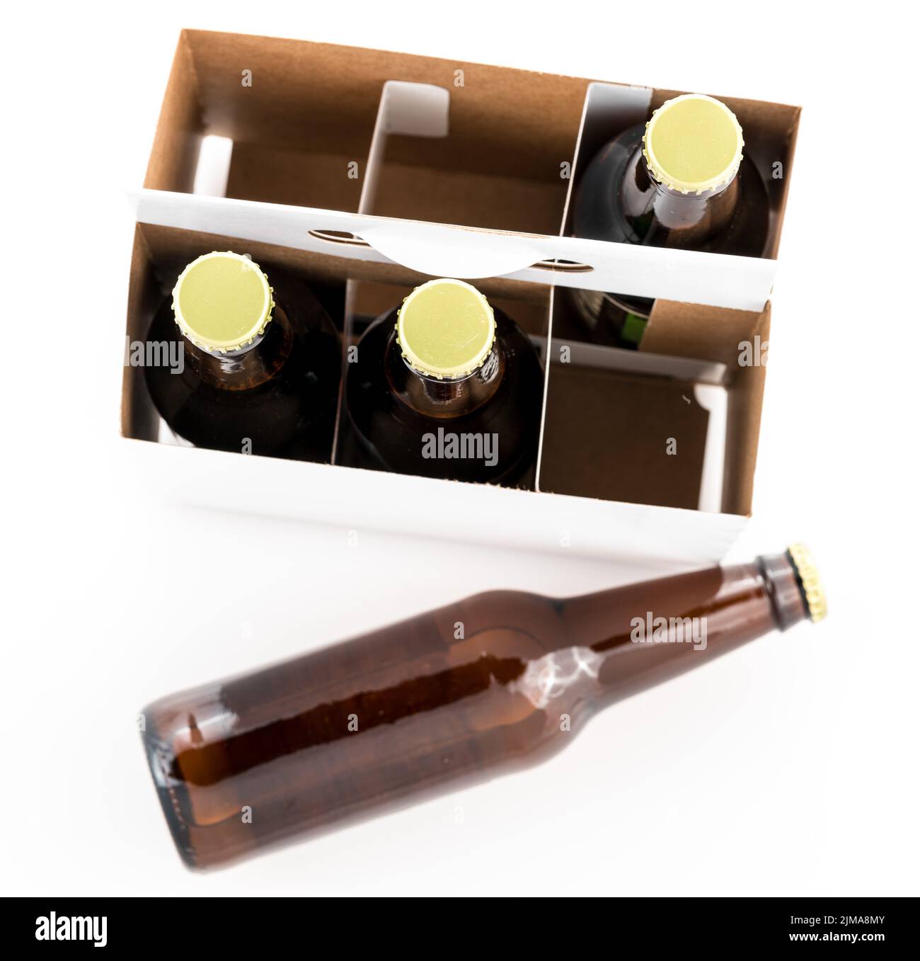 Three bottles of beer with caps and one on side Stock Photo