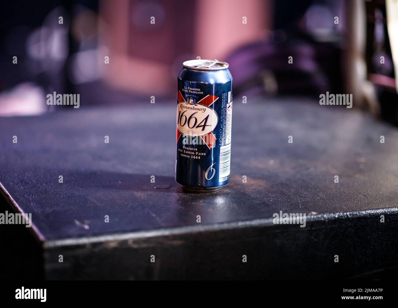 Can of Kronenbourg 1664 beer on a black surface in a music venue in the UK with copy space. Stock Photo