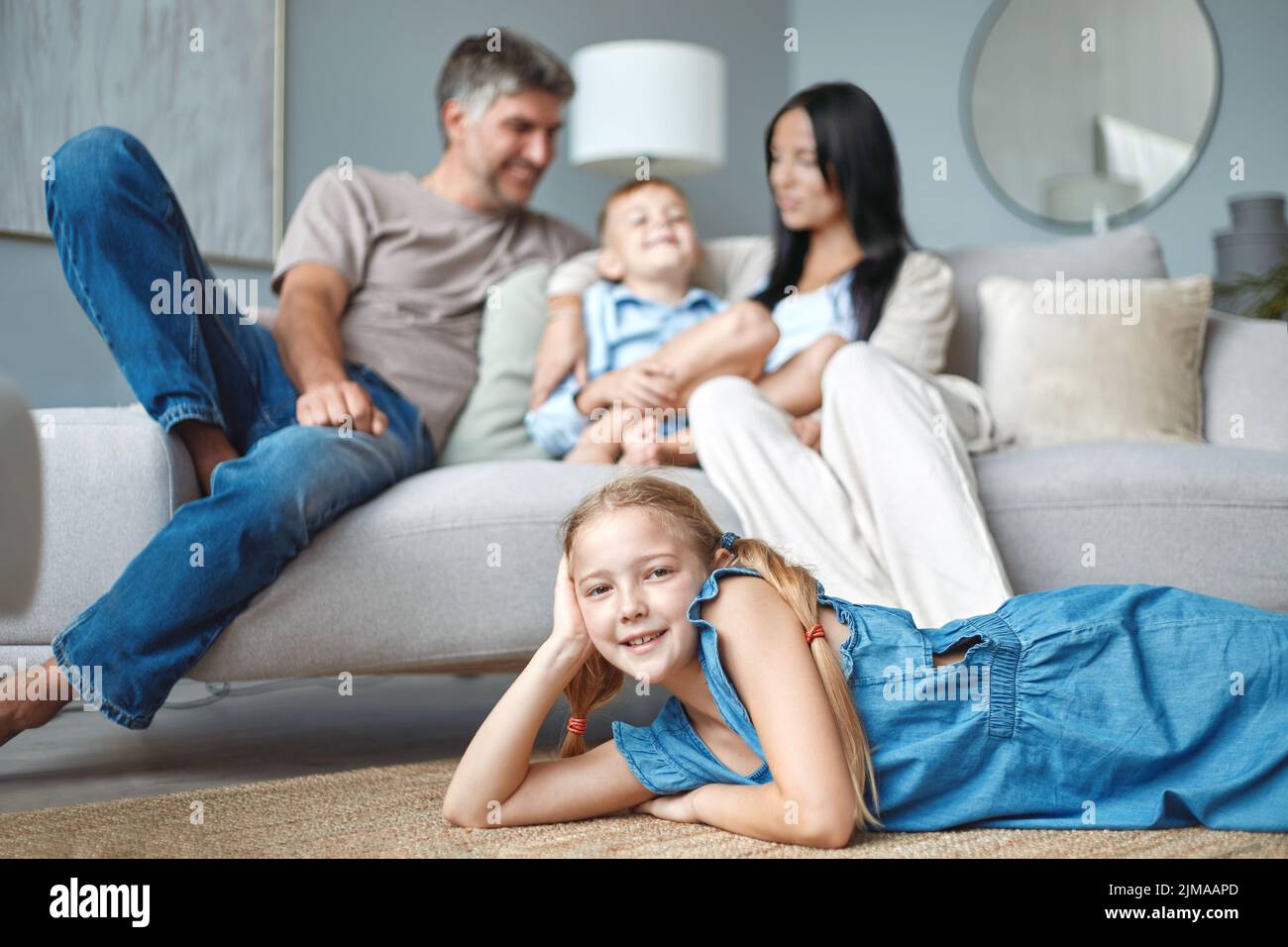 Cute little girl lying on the floor and smiling at camera Stock Photo ...