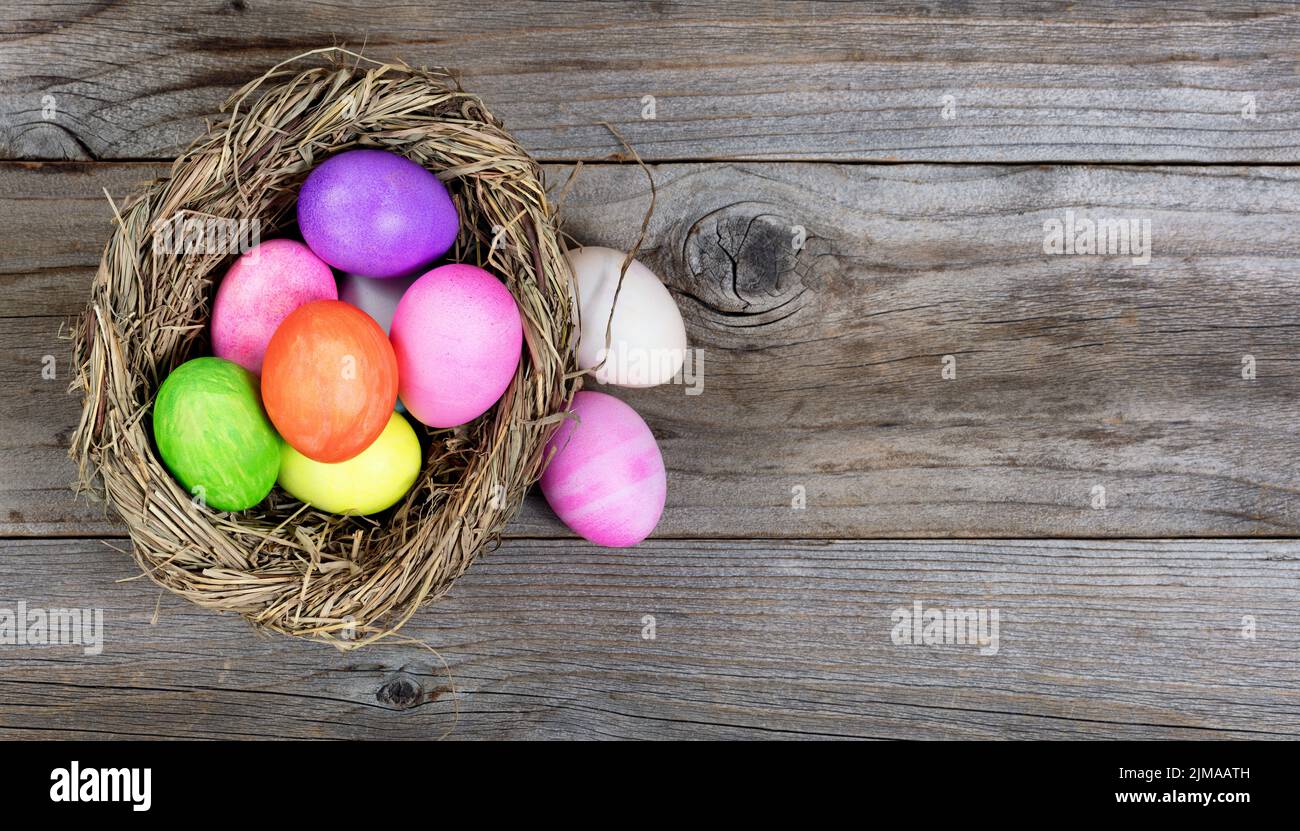 Nest with colorful eggs for Easter holiday on rustic wooden boards Stock Photo
