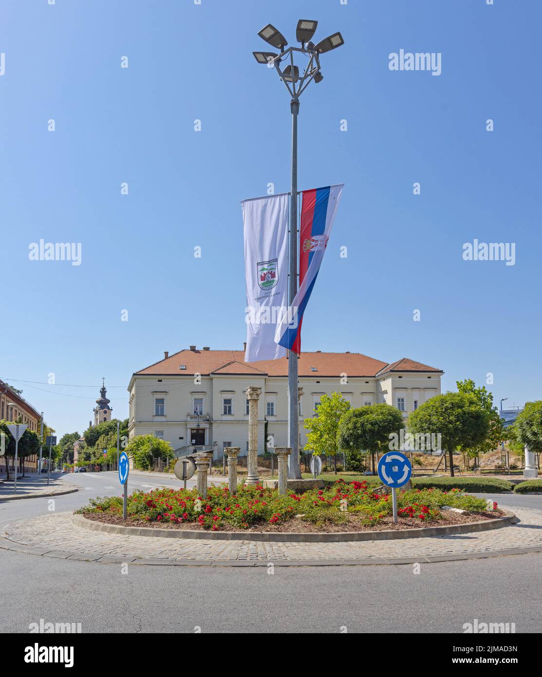 Sremska Mitrovica, Serbia - July 22, 2022: Museum of Srem Building and Roman Columns Artifacts at Roundabout Intersection in City. Stock Photo