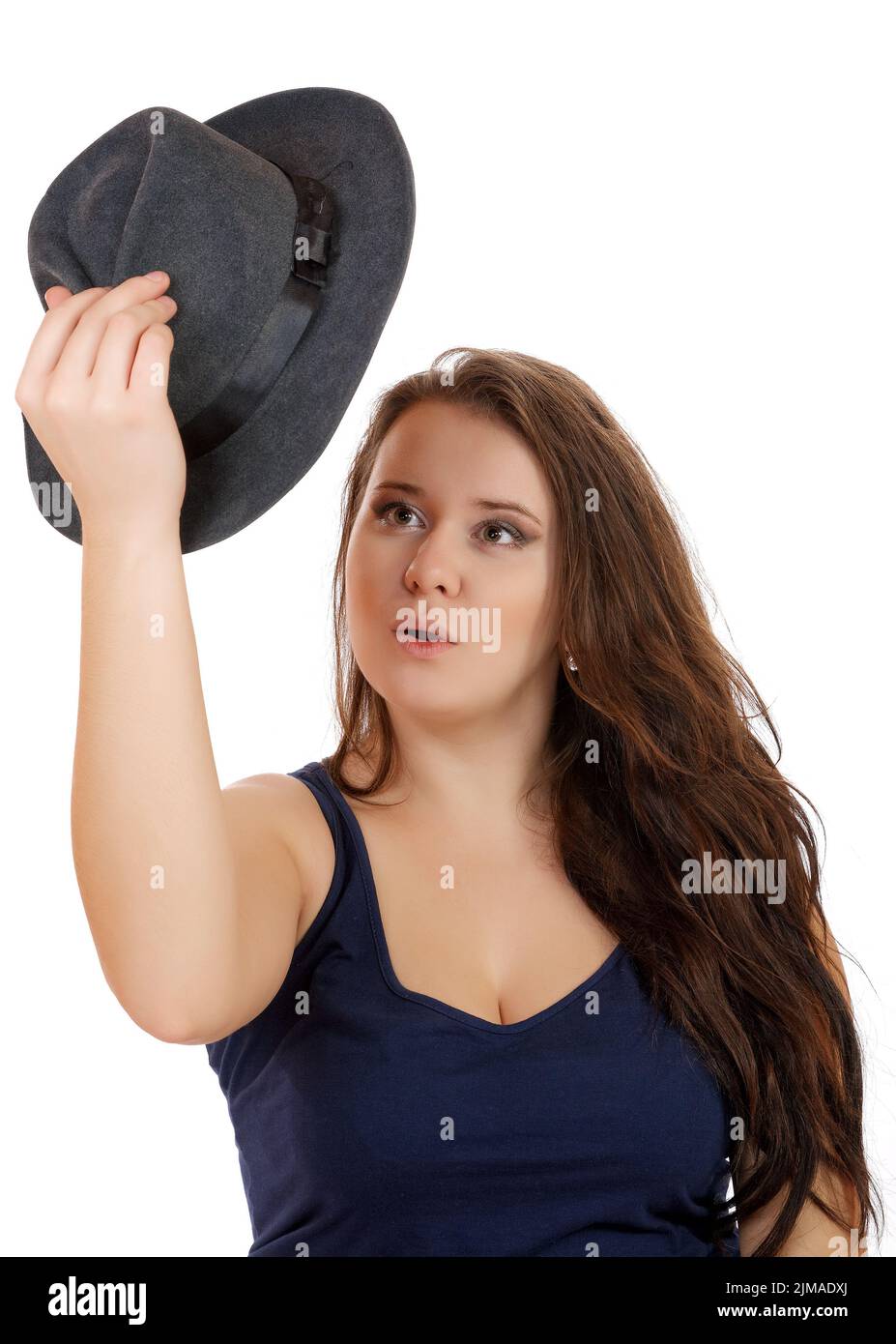 The girl looks surprised at the hat in her hand on a white background Stock Photo