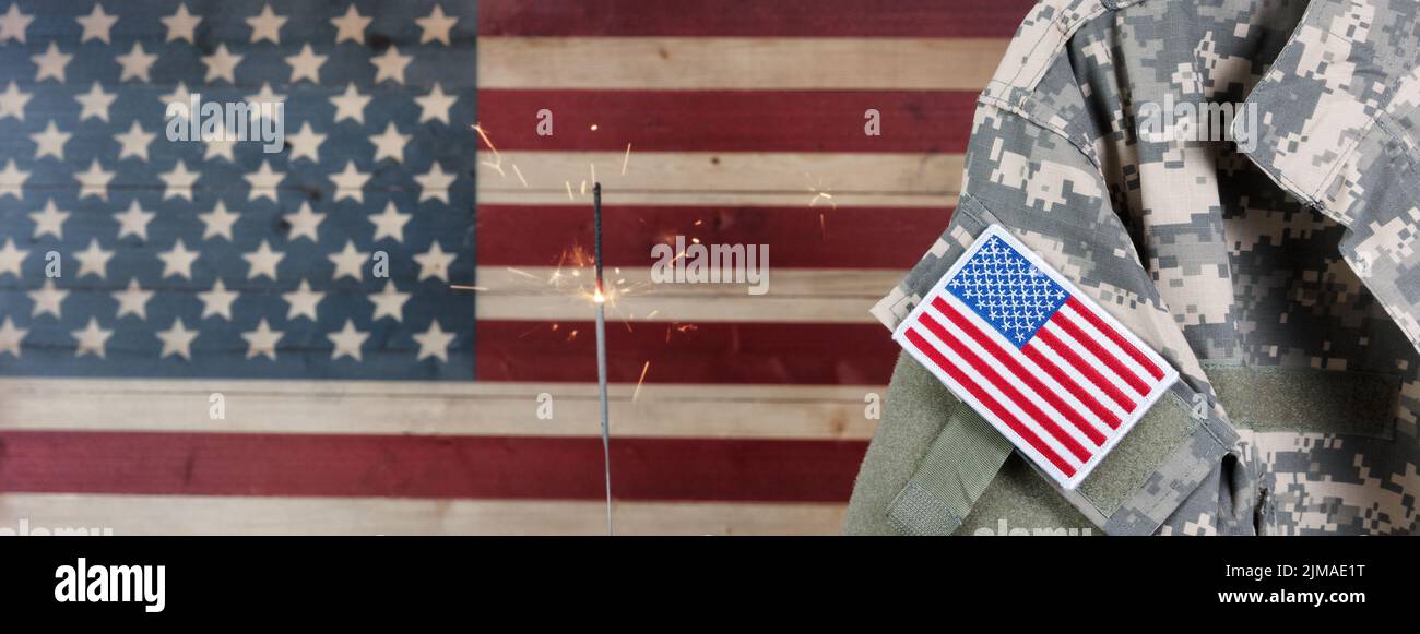USA military uniform with rustic wooden flag of United States of America and sparkler in background Stock Photo