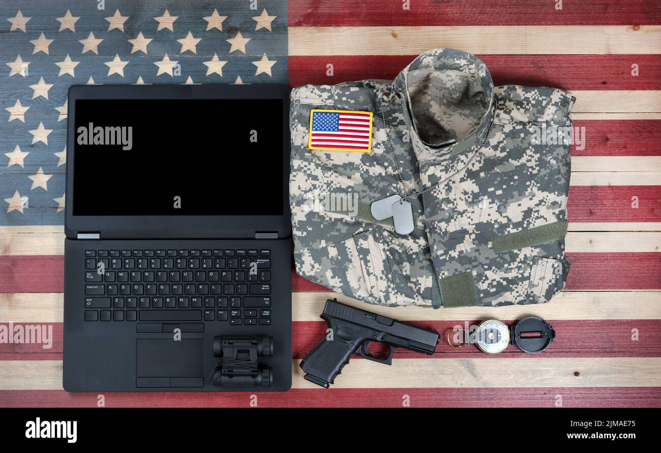 Overhead view of USA military equipment and laptop computer on rustic wooden flag Stock Photo