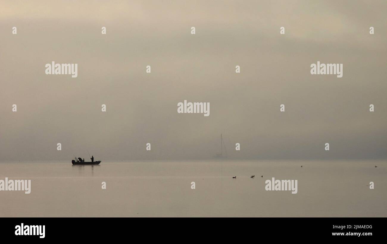 Fishing boat in the fog lake constance Stock Photo Alamy