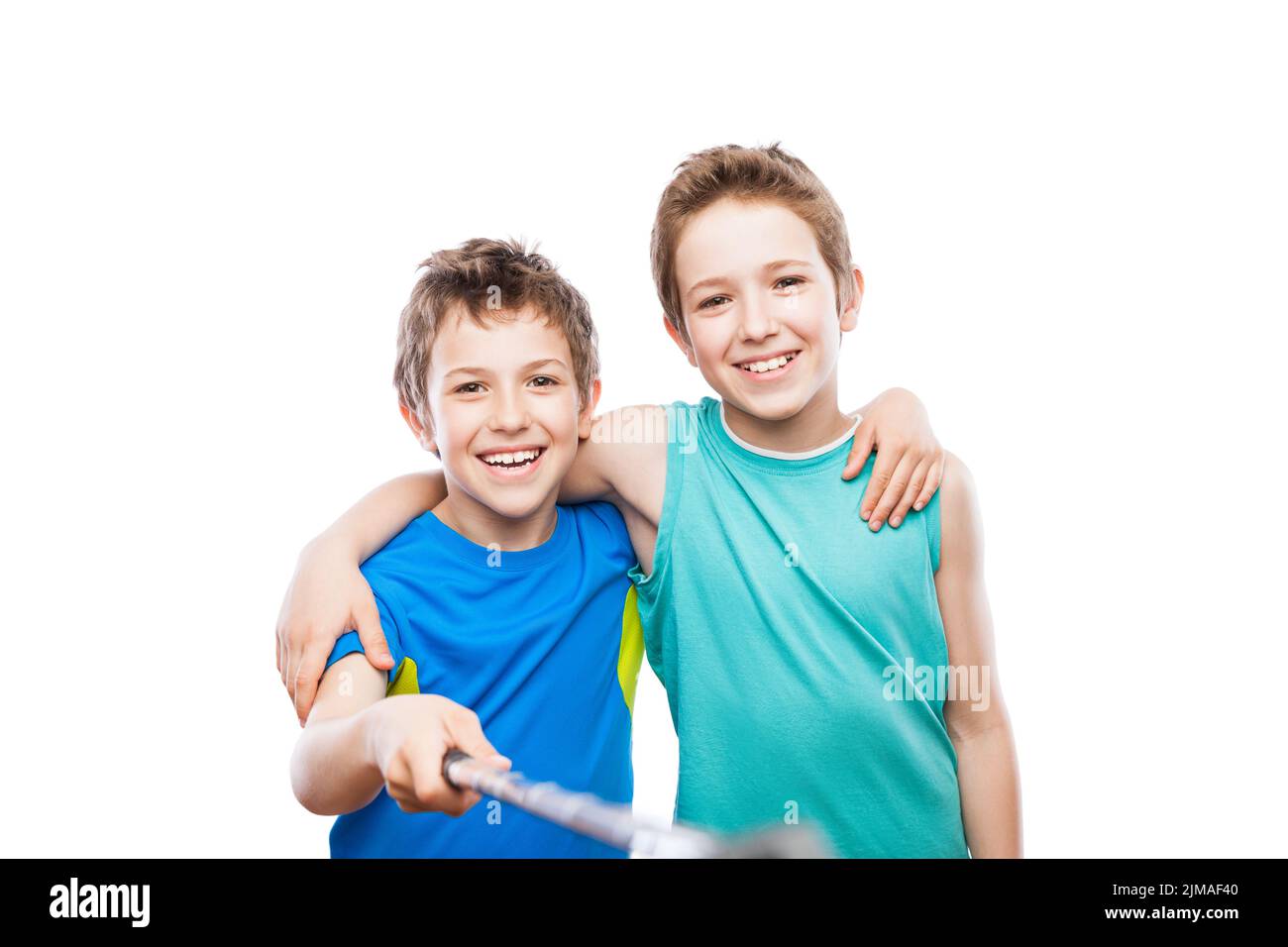 Two smiling child boy brothers holding mobile phone or smartphone selfie stick taking portrait photo Stock Photo